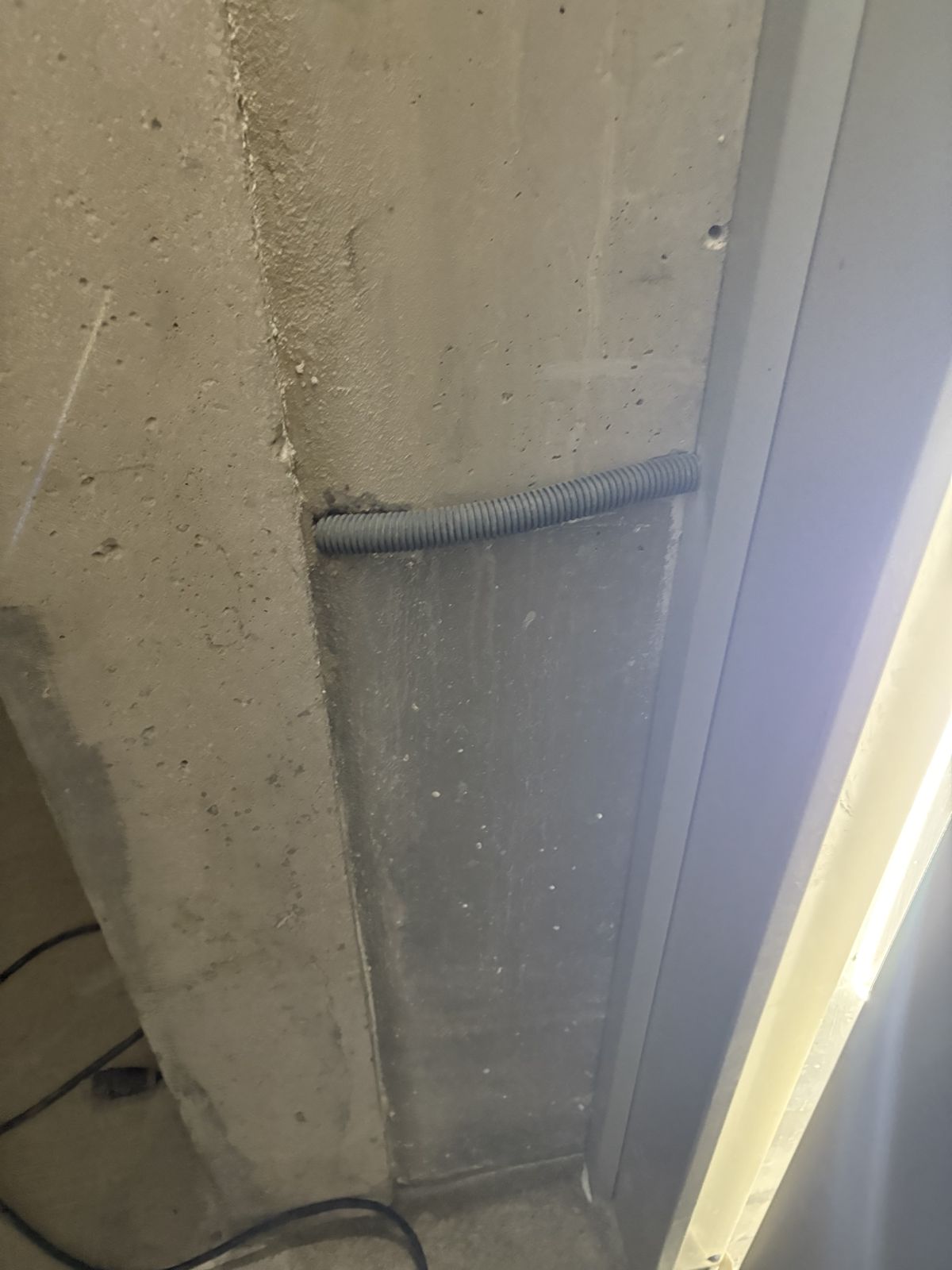 Poteau béton et gaine électrique dans un local technique